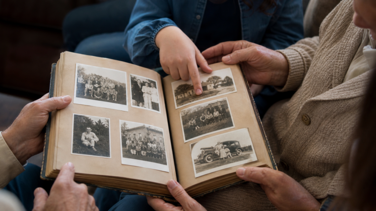 respectful photo of family hands holding old photo album. 16x9 aspect ratio